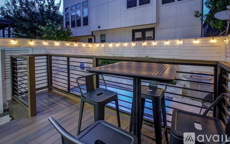 A balcony with a table and chairs is set up for an evening of relaxation.