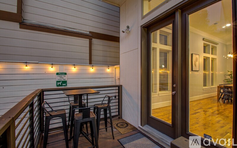 A patio area with a table and chairs and lights on the wall.