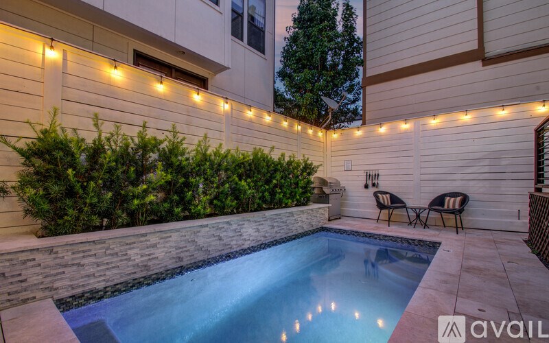 A pool surrounded by lights and plants.
