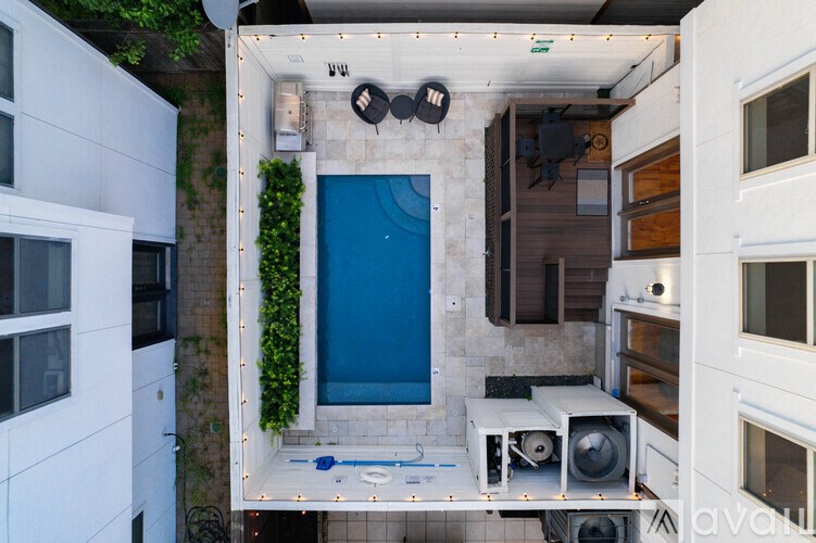 A small pool in a balcony surrounded by white walls.