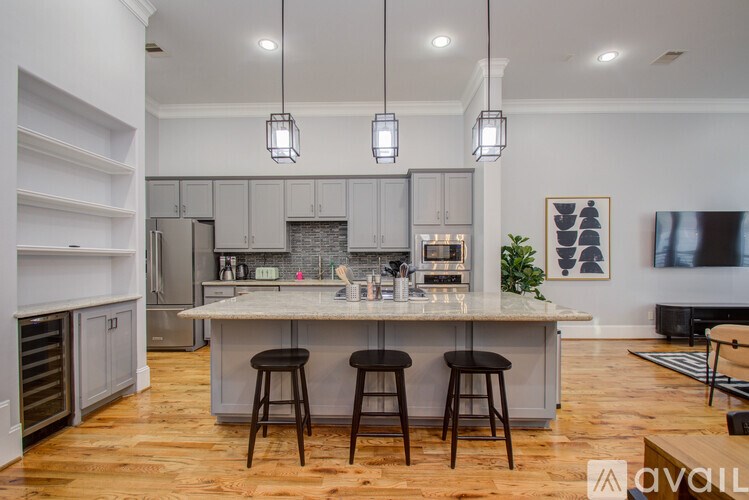 A kitchen with a bar and stools in front of it.