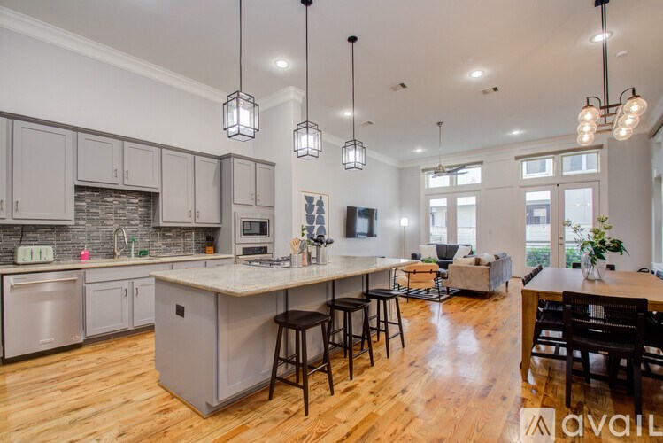 A kitchen with wooden floors and a large island with bar stools.