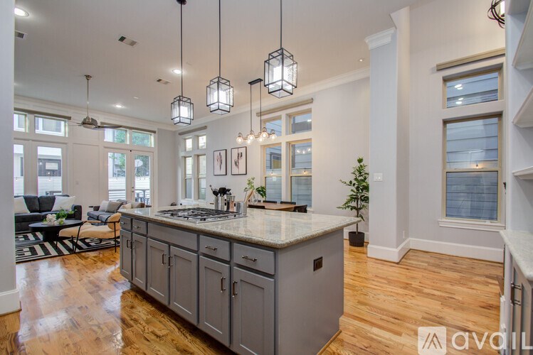 A kitchen with a large island and pendant lights.