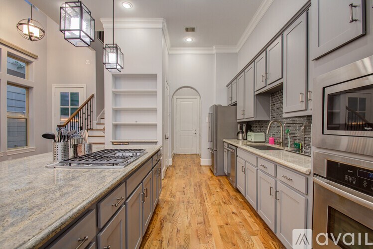 A modern kitchen with a marble countertop and stainless steel appliances.