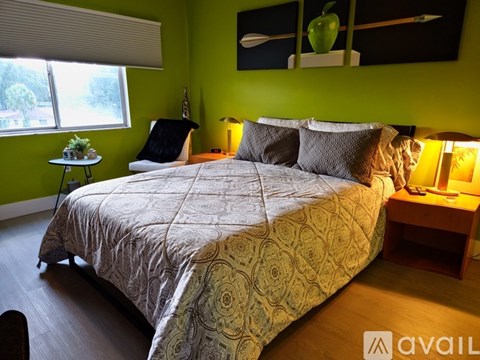A bedroom with a large bed and a green wall.