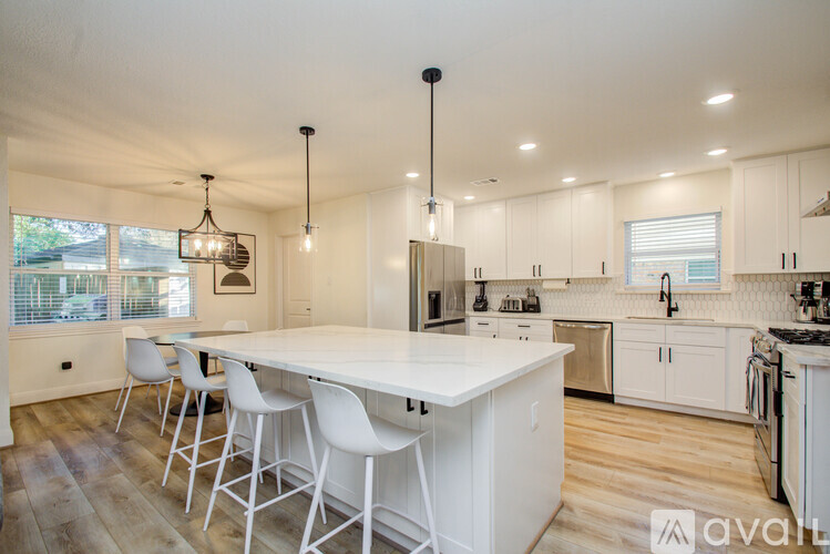 A kitchen with white cabinets and a large island.
