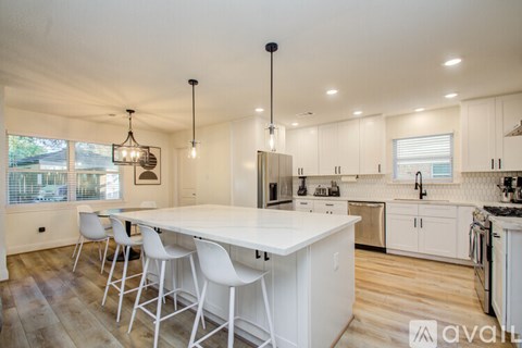 A kitchen with white cabinets and a large island.