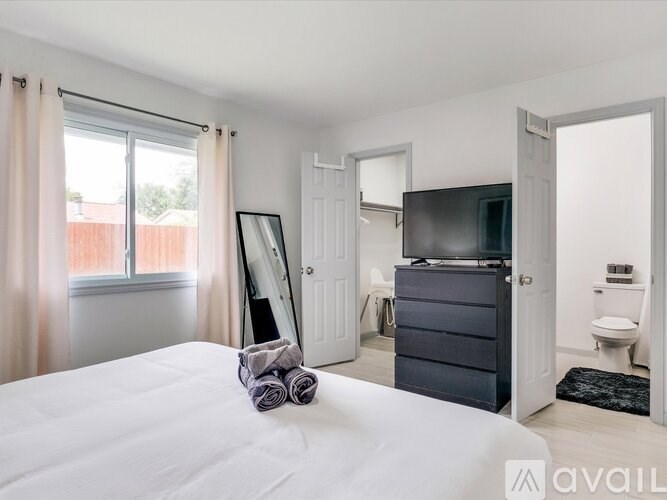 A bedroom with a bed, dresser, and mirror.