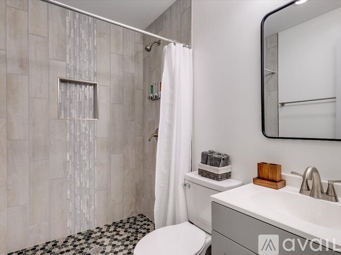 A bathroom with a white toilet, a sink, and a shower with a glass door.