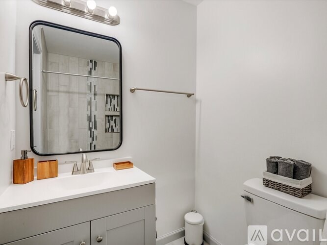 A bathroom with a white sink, mirror, and toiletries.