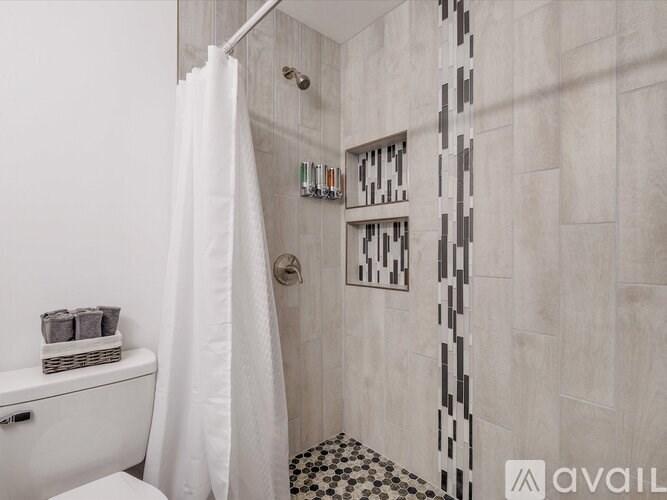 A bathroom with a white toilet and a shower with a white curtain.