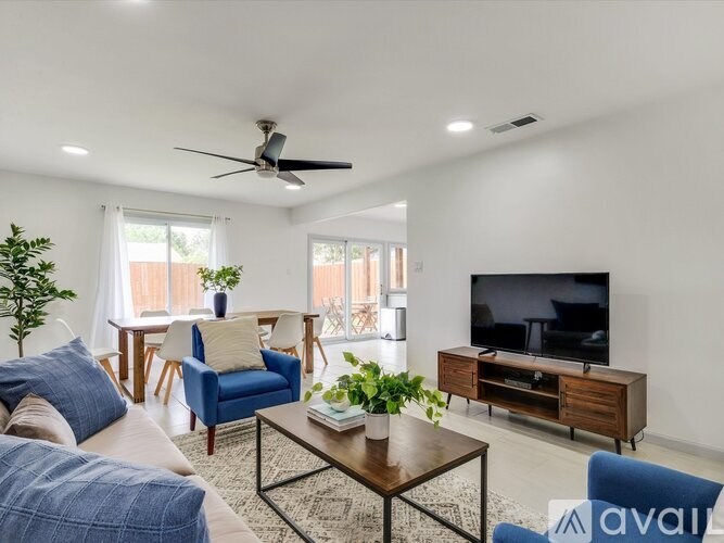 A living room with a blue chair and a television.