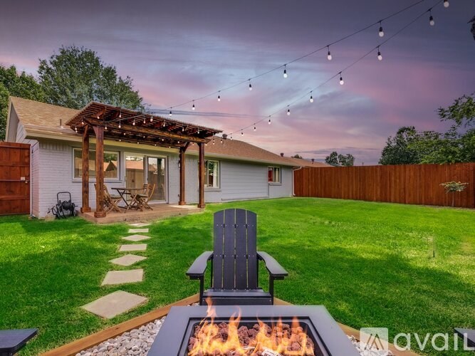 A backyard with a fire pit and a chair.