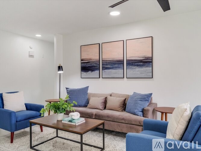 A living room with a blue couch, a brown couch, and a coffee table with a plant on it.