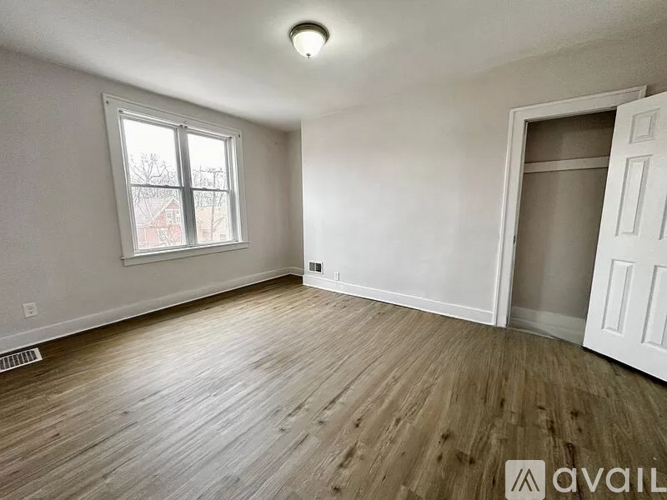 A room with wooden flooring and a window.