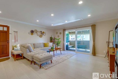 A living room with a white sofa and a rug in the middle.