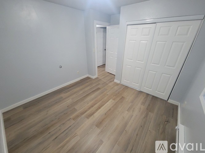 A room with wooden flooring and white walls.