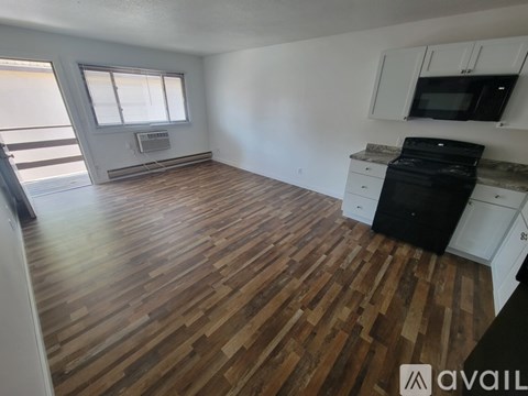 A kitchen with black appliances and white cabinets.