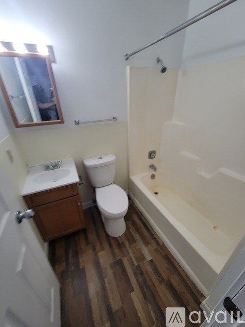 A bathroom with a toilet, sink, and bathtub.