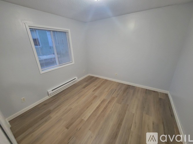 A room with a window and a wooden floor.
