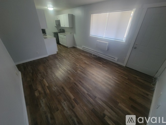 A room with wooden flooring and white walls.