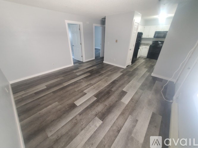 A room with wooden flooring and white walls.
