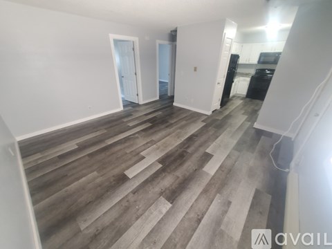A room with wooden flooring and white walls.