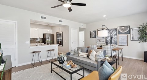 A living room with a grey couch and a coffee table in the middle.