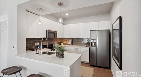 A modern kitchen with a white countertop and stainless steel appliances.