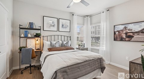 A bedroom with a bed, a chair, a shelf with books and a plant, and a painting on the wall.