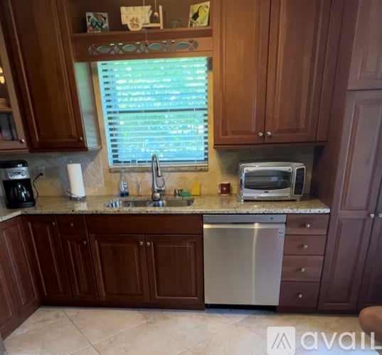 A kitchen with brown cabinets and a granite countertop.