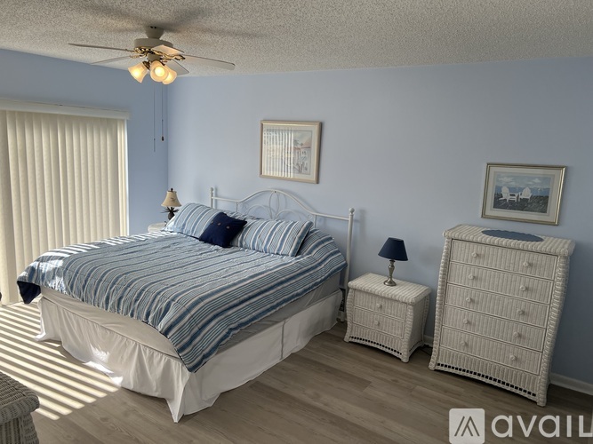 A bedroom with a large bed, a nightstand, and a dresser.