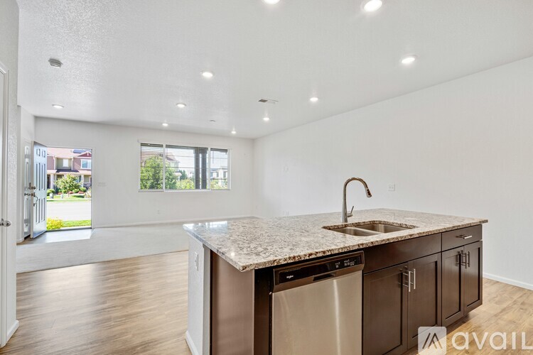 A kitchen with black cabinets and a granite countertop.