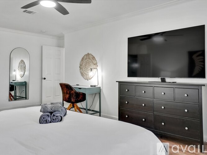 A bedroom with a bed, desk, and chair.