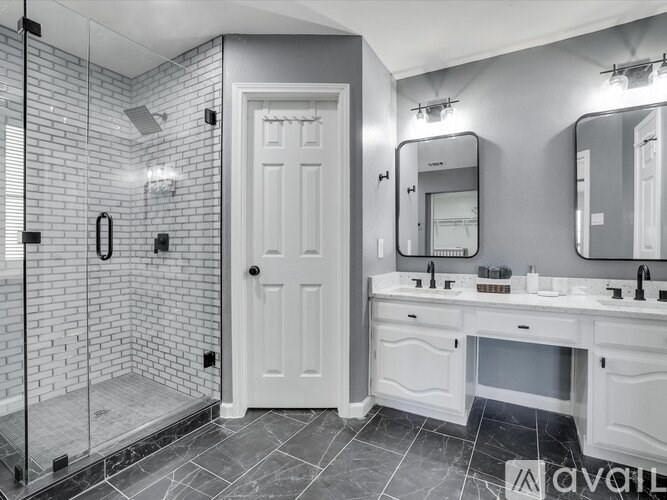 A bathroom with a white door and a tiled shower area.