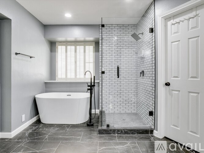 A white bathtub is in a bathroom with a walk-in shower.