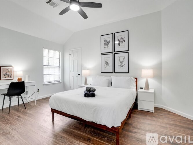 A bedroom with a bed, chair, and pictures on the wall.