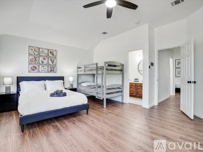 A bedroom with a bed, bunk beds, and a ceiling fan.