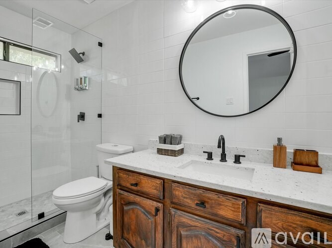 A bathroom with a toilet, sink, and mirror.