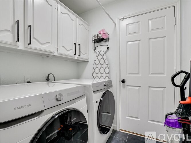 A white Samsung washing machine and dryer in a laundry room.