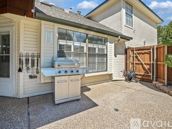 A house with a white outdoor kitchen and a grill.