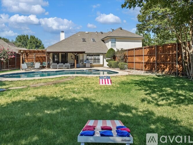 A backyard with a pool and a picnic table with an American flag on it.