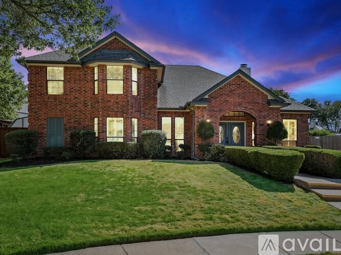 A house with a well-manicured lawn and a clear sky in the background.