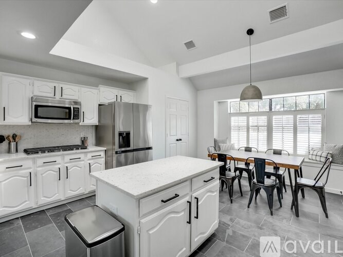 A modern kitchen with white cabinets and a large island.