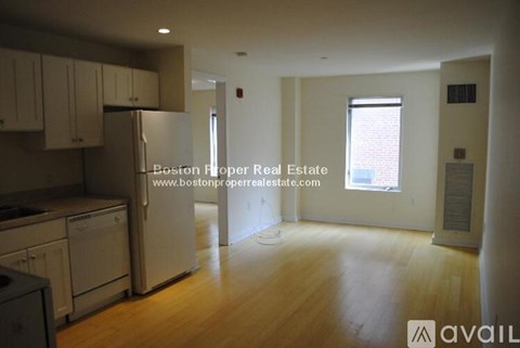 A kitchen with wooden floors and white appliances is available for rent.