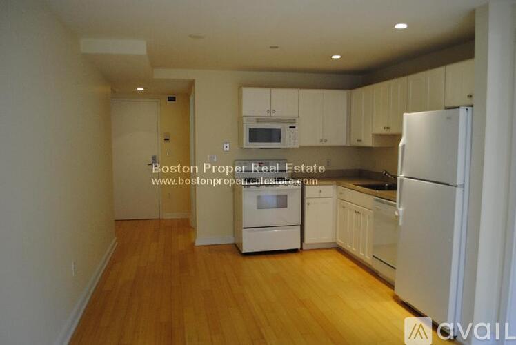 A kitchen with wooden floors and white appliances.