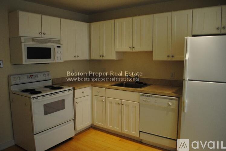 A kitchen with white appliances and cabinets.