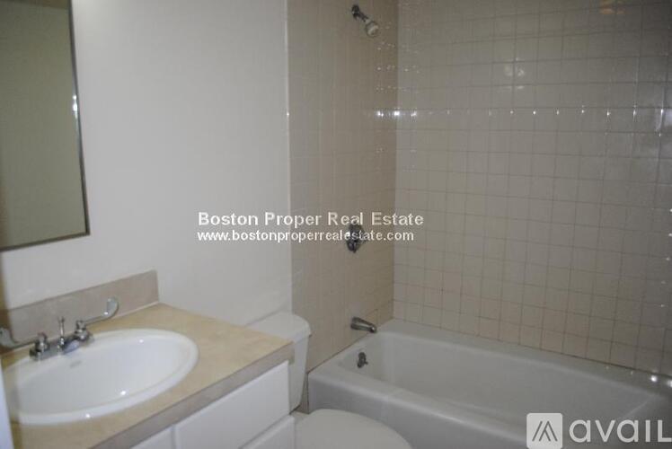 A bathroom with a tub, sink and toilet.