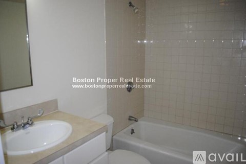 A bathroom with a tub, sink and toilet.