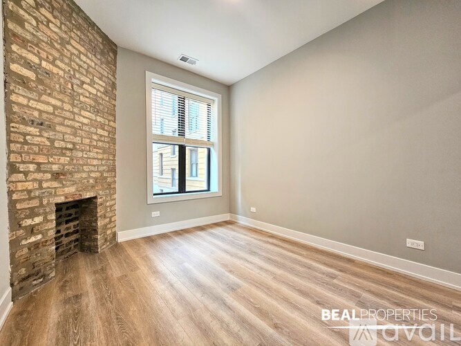 A room with a brick fireplace and wooden flooring.